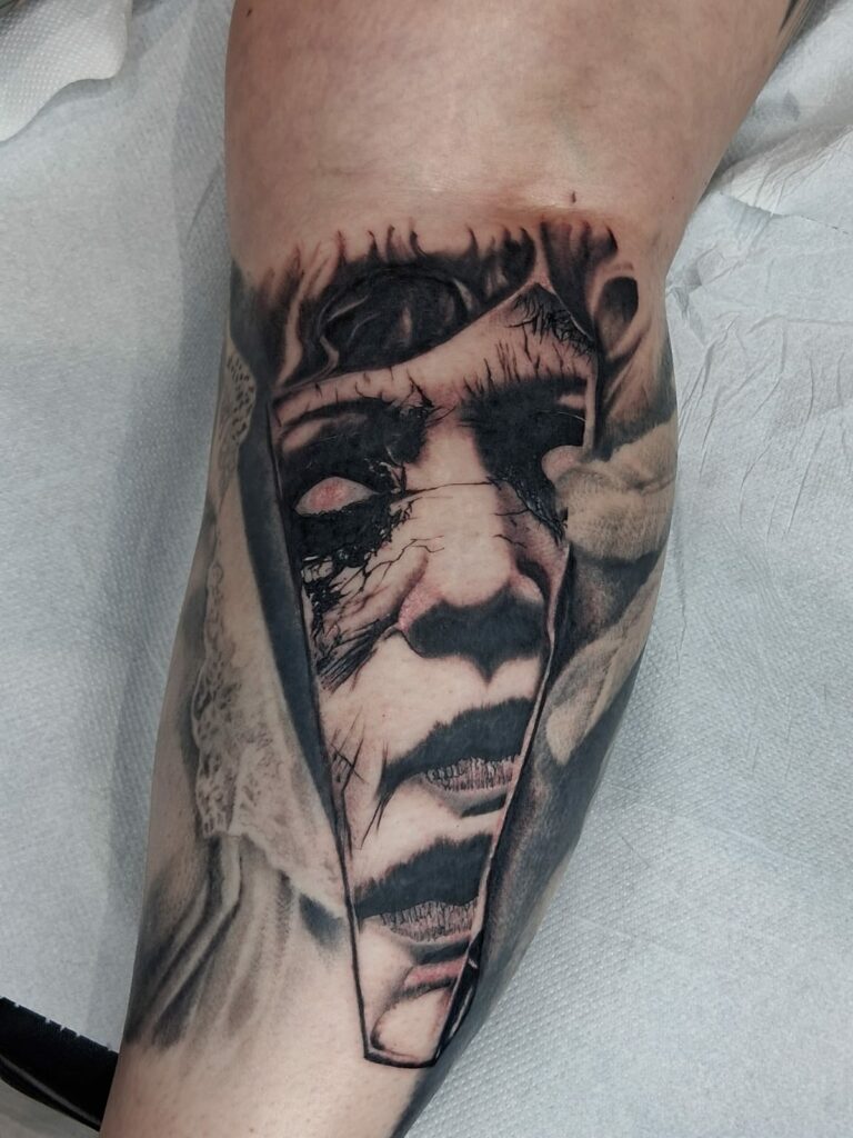 Tatouage portrait réaliste noir et gris sur la jambe à Troyes