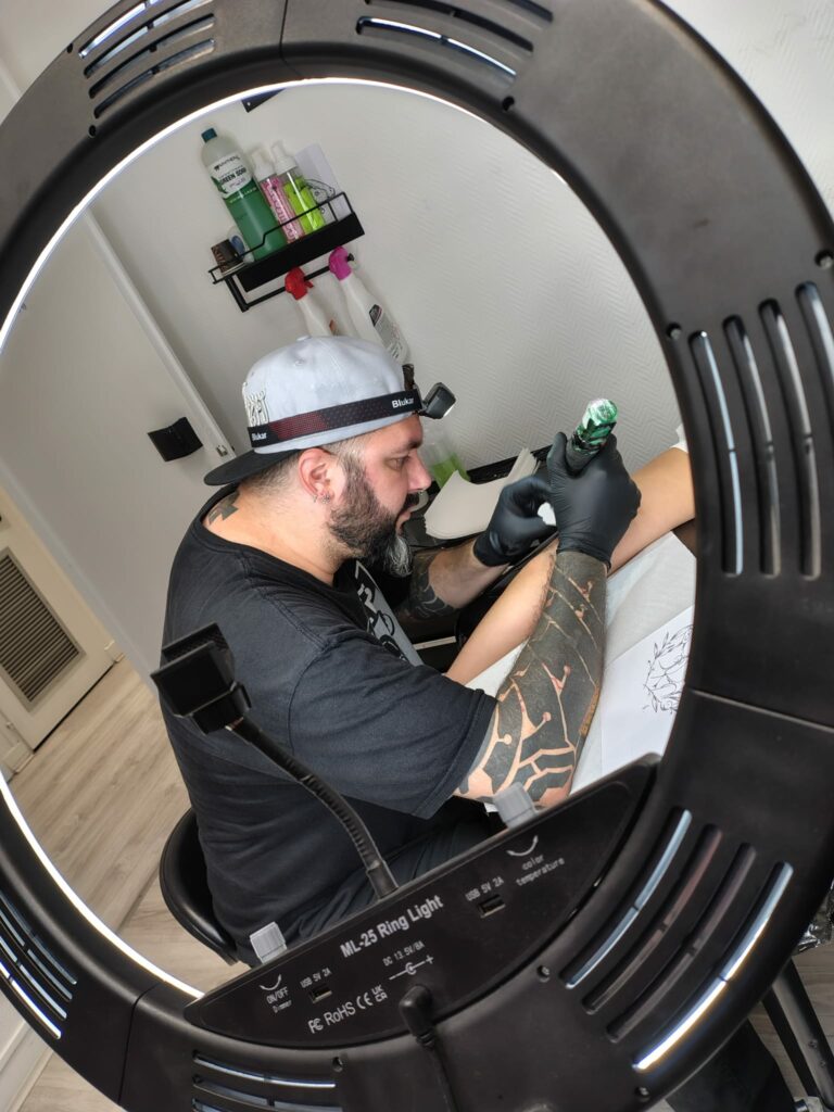 Tatoueur réalisant un tatouage pendant une séance à Troyes
